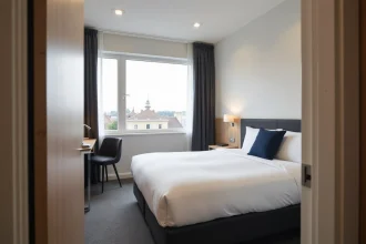 Chambre double confortable à l'hôtel ibis de Fécamp avec lit blanc et vue sur ciel normand