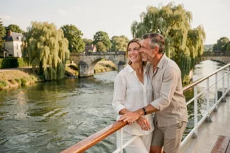 Couple souriant sur le pont d'une croisière fluviale pas chère sur la Loire en France