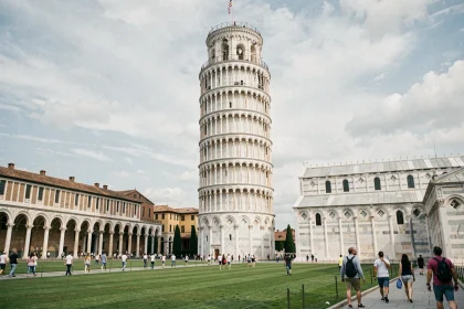 Vue grand angle de la Tour de Pise inclinée sur la Piazza dei Miracoli entourée de pelouses vertes et de touristes
